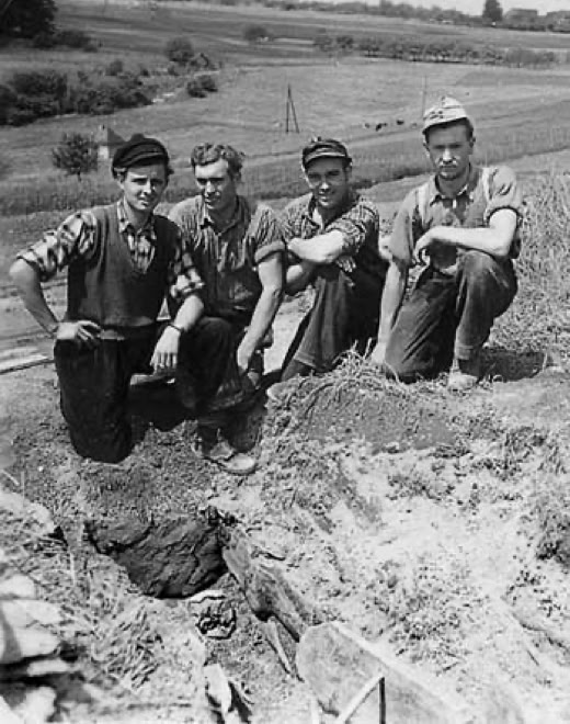 Foto Bimsgrube mit vorgeschichtlichem Grab, dahinter die vier Bimsarbeiter, die das Grab entdeckten.